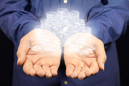 A lot of euro coins floating above two hands.の写真素材