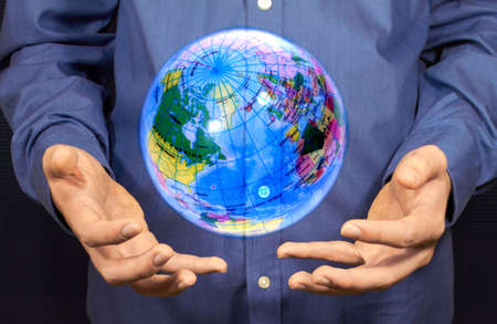 A magic globe hovering above two hands.の写真素材