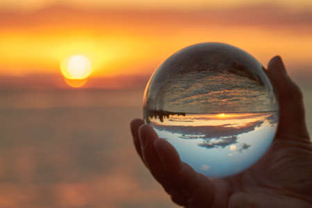 The sun sets over Lake Constance in Germany and lit by a crystal ball.の写真素材