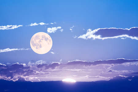 The sun and the moon can be seen in the sky Simultaneously.の写真素材