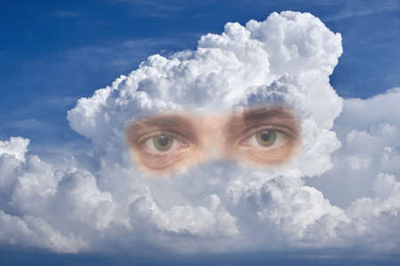 In the sky is a large bright thundercloud with two eyes.の写真素材