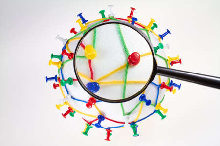 Colorful wool threads on a globe form a network between pins.の写真素材
