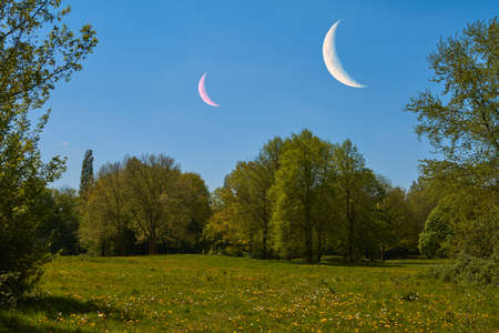 Two moons are above at idyllic landscape.の写真素材