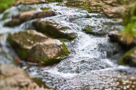 Quick over rocks water flowing in a stream.