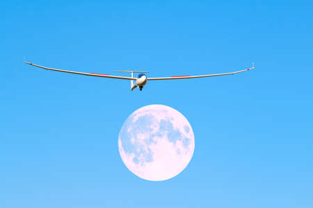 A sailplane in front of a blue sky glides through the air without its own motor drive.