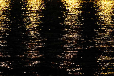 Light rays reflected on a water surface in motion.の写真素材