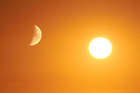 The sun and the moon can be seen in the sky.の写真素材