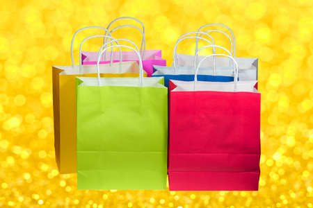 Six colorful paper bags standing in one heap.