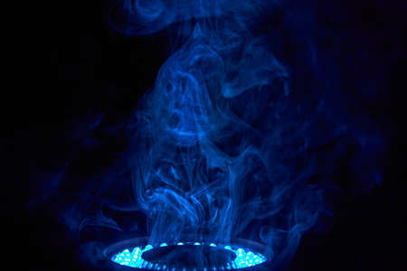 A cloud of smoke is illuminated by an LED ring light.の写真素材