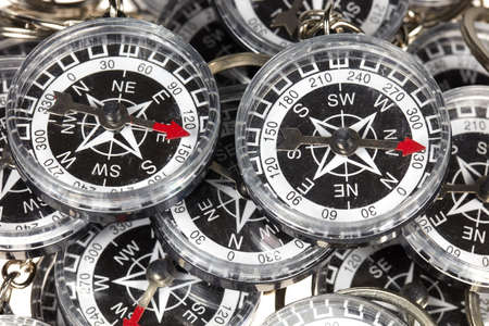 A bunch of small round compasses with a red pointer.
