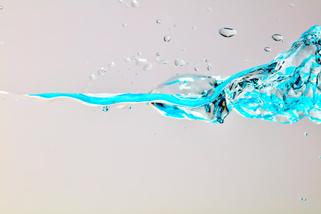 Close up of blue wave and air bubbles against a bright background.