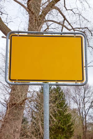 Yellow sign without content in front of a tree in winter.の写真素材
