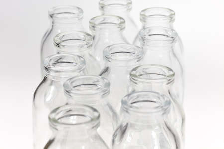 Small transparent glass bottles against white background.の写真素材
