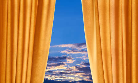 A slightly raised curtain provides a view of the sky.の写真素材