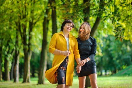 the adult daughter embraces the elderly mother and and together smileの写真素材