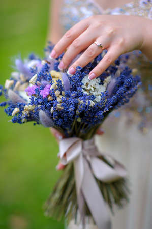 girl holds a beautiful bouquet from a bright blue lavenderの写真素材