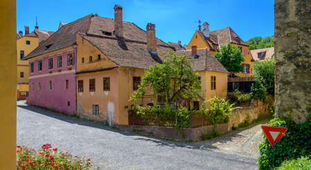 Streets of the old city of Sighisoara in Transylvania, historical constructions, bright multi-colored houses, old kiripichny roofsの写真素材