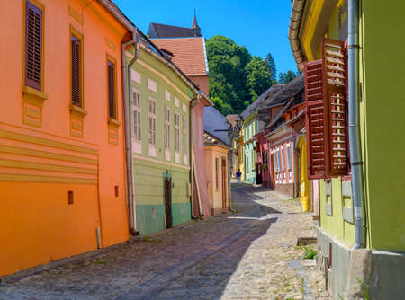 multi-colored houses of the old city of Sighisoara, the street paved stones, houses are painted multi-colored colorsの写真素材