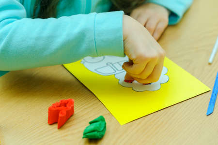 Children at a lesson of the fine arts, are engaged in application and a rusovaniye, rusut and decorate on contours, I paste strips of color paper, prepare gifts for holidaysの写真素材