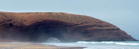 Natural arches on the beach of a legzir in Morokko, Two huge arches from red breed in a rebag with a...