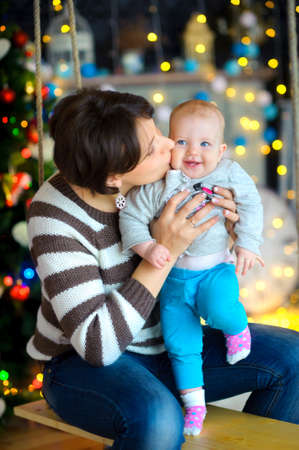 Waiting for Christmas. Mother with the little daughter, embraces and together smile. New Year People