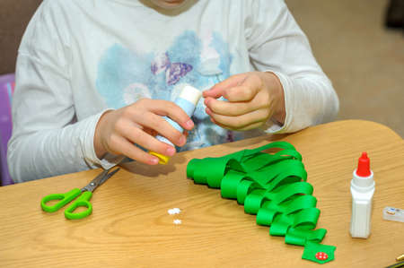 Children at a lesson of the fine arts, make gifts for a holiday of Christmas and new year. Cut out...