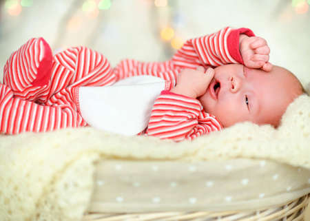 newborn baby sleeps on white fur, a Christmas backgroundの写真素材