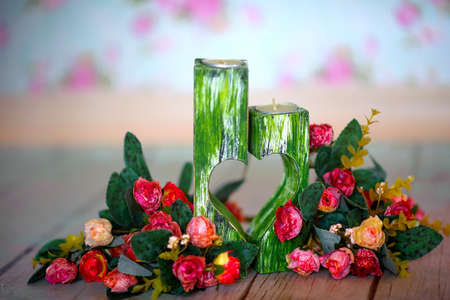 two wooden decorative candlesticks, with two halves of hearts which are cut out in themの写真素材