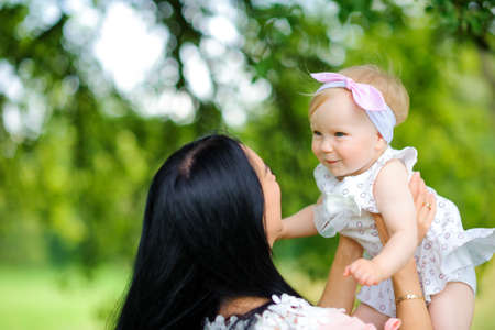 mother with the beloved daughter walks in the beautiful park, play and have fun