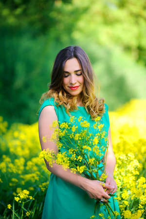 beautiful girl in a green dress walks in the flower field