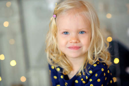 portrait of the little beautiful girl at birthday, smiles and looks in the camera