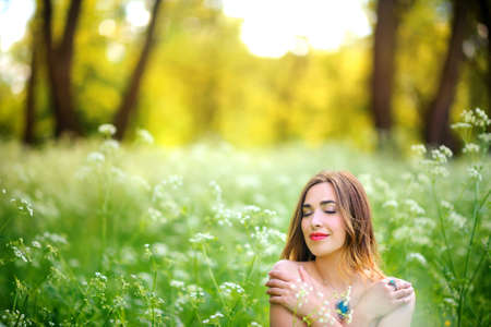 beautiful girl walks in the evening park during a sunsetの写真素材