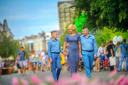 happy family walking in the city on a busy street in a bright sunny dayの写真素材