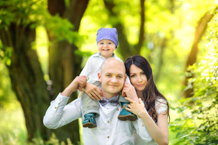 young family walks with kids in the beautiful park on a sunsetの写真素材