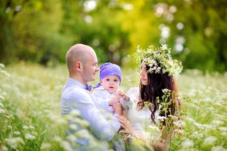 family walks in the beautiful park on a sunset, play and have fun, mother with a wreath on the headの写真素材