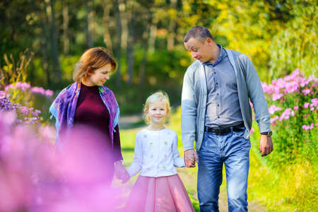 happy family walking in the evening parkの写真素材