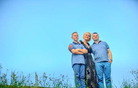 family dreams and looks into the distance against a blue sky backgroundの写真素材