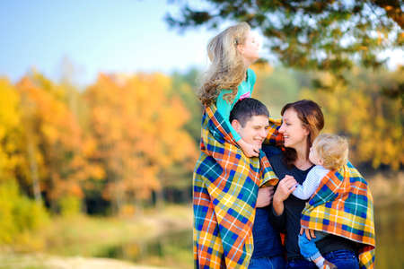 happy family walking in a beautiful autumn park, hugging and having funの写真素材