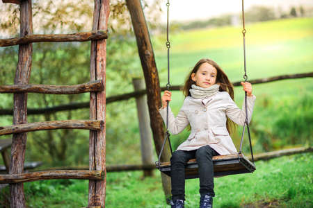 the girl is riding on a swingの写真素材