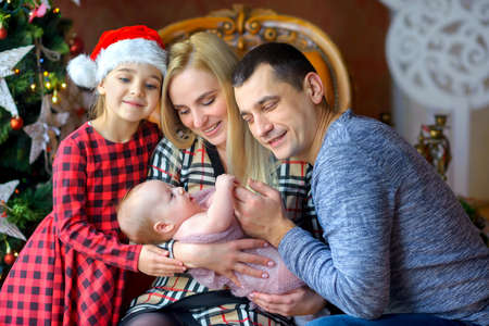 happy family near the Christmas tree, waiting for the holiday