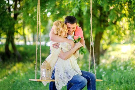 Couple resting outdoors, the girl admires her bouquetの写真素材
