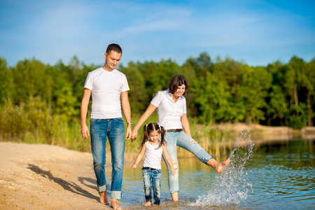 happy family walks on the nature near the lake, go for a ride on the water and splash