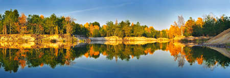 bright, rich colors of autumn foliage reflected in the lakeの写真素材