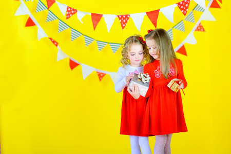 beautiful little girls in smart dresses with gifts in handsの写真素材