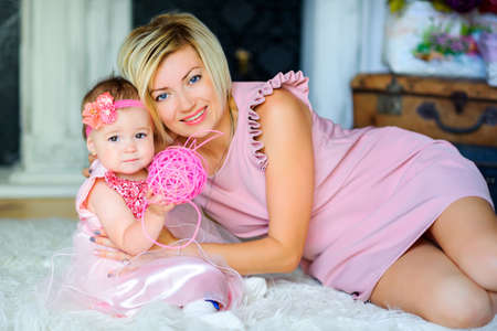 happy mother with her beloved daughter, lie on the floor and smile