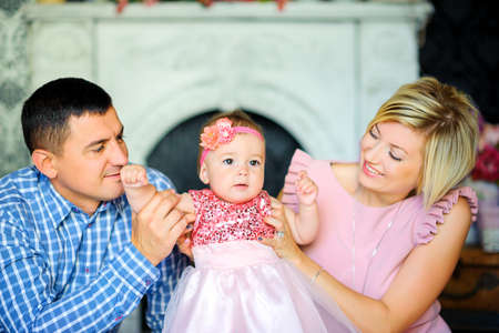 happy family in their home, parents hug their baby and smile