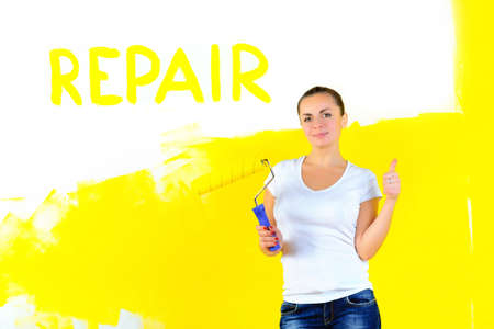 girl painter with paint roller for painting, on with a shadow inscription repair, shows class