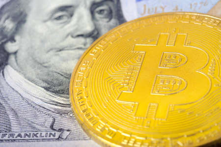 a close-up shot, a bitcoin coin lies on a hundred dollar bill