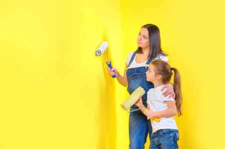 mom and daughter make repairs in the room, get ready to paint the wallsの写真素材