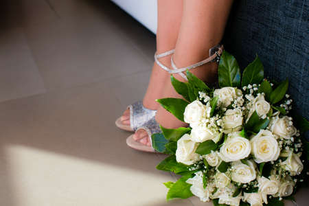 Wedding flowers and legs of the brideの写真素材